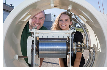 Graduate student Jonathan Ferry and undergraduate mechanical engineering major Jordyn Brinkley show off the solar-powered drum dryer.